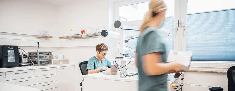 Einblick in unserer Dentallabor: Unsere Mitarbeiterin arbeitet gerade an einem Zahnmodell.